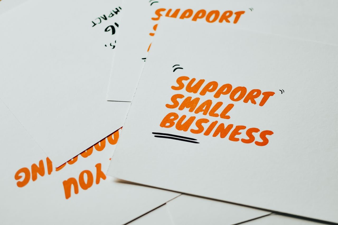 Hello world! Close-up of motivational cards promoting support for small business on white background.
