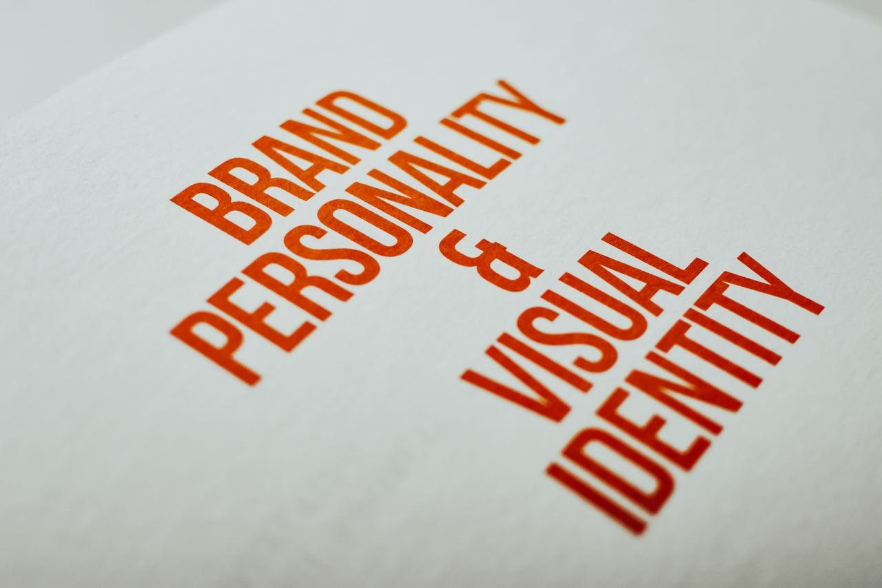 ours-journey Close-up of 'Brand Personality & Visual Identity' text in red on white paper.